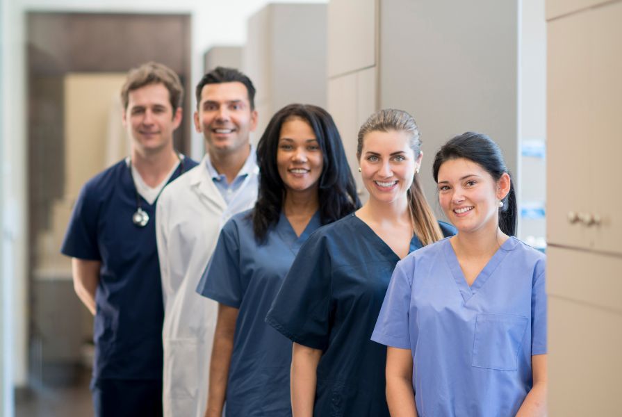 Five healthcare staff members, nurses and doctors from different ethnicities